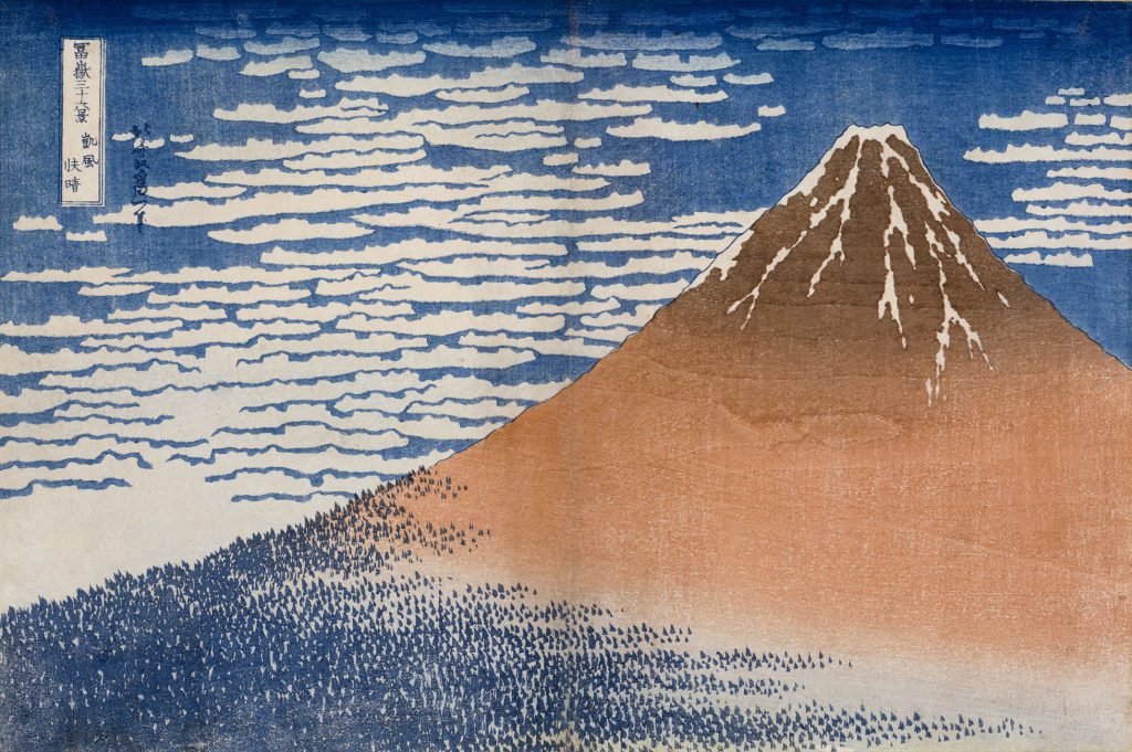 A woodblock print of a single tall brown mountain, its peak streaked with snow and base dotted with blue, over a background of deep blue sky and lined with clouds.