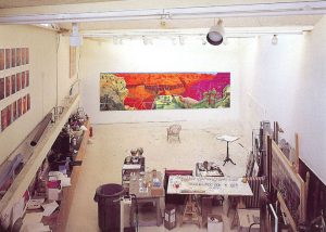 A photograph of Hockney's studio with The Grand Canyon painting covering much of the far wall.