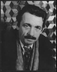 A black and white headshot-style photograph of Thomas Hart Benton dressed in a suit with a geometric background.